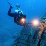 Водолаз се гмурка под водата в търсене на останки от кораб.