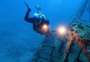 Водолаз се гмурка под водата в търсене на останки от кораб.