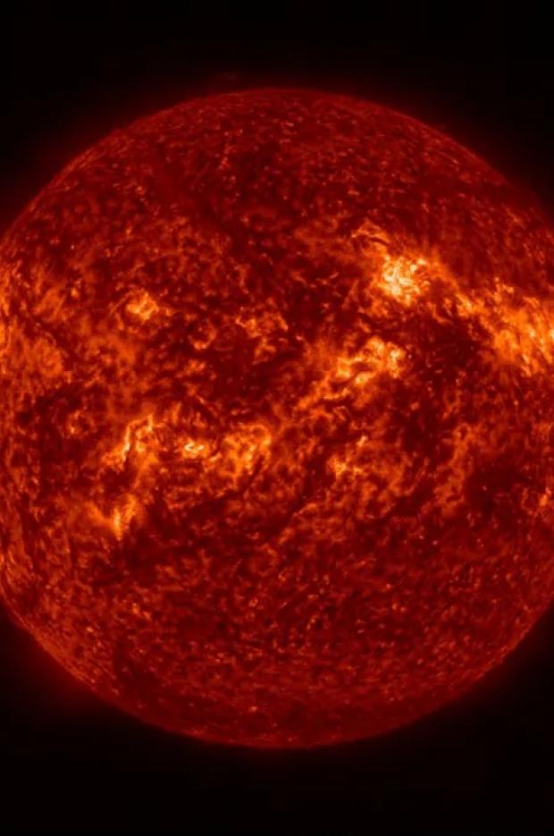 Ултравиолетово изображение на Слънцето, показващо ярки активни области, тъмни петна и изригвания по огненочервената му повърхност.